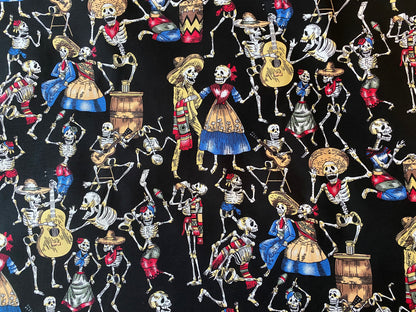 Fabric with colorful skeletons in traditional Mexican attire on a black background
